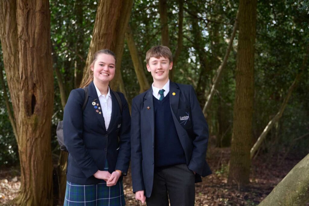 2 students stood in the woods